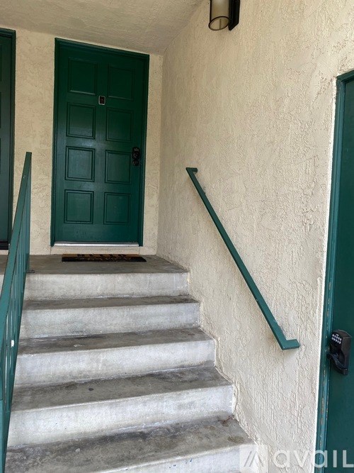 A green door is at the end of a staircase.
