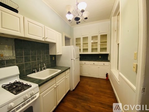 A kitchen with white cabinets and a white stove.