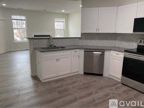 A kitchen with white cabinets and a grey countertop.