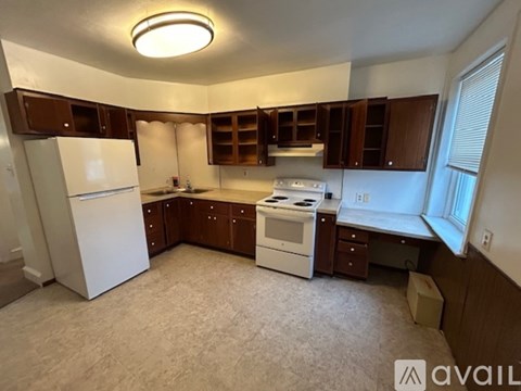 A kitchen with white appliances and brown cabinets.