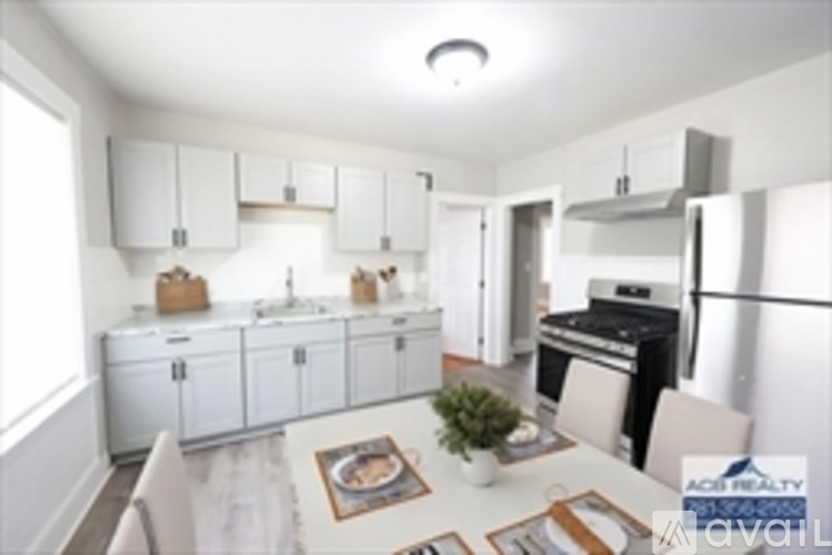 A white kitchen with a table and chairs.