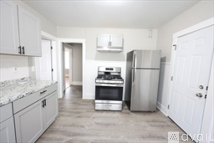 A kitchen with white cabinets and a marble counter top.