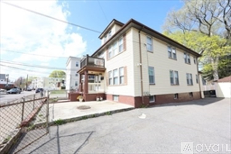 A two-story building with a brown roof and a parking lot in front.