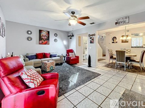 A living room with a red chair and a black and white rug.