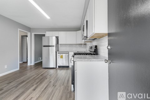 A kitchen with white cabinets and a stainless steel refrigerator.