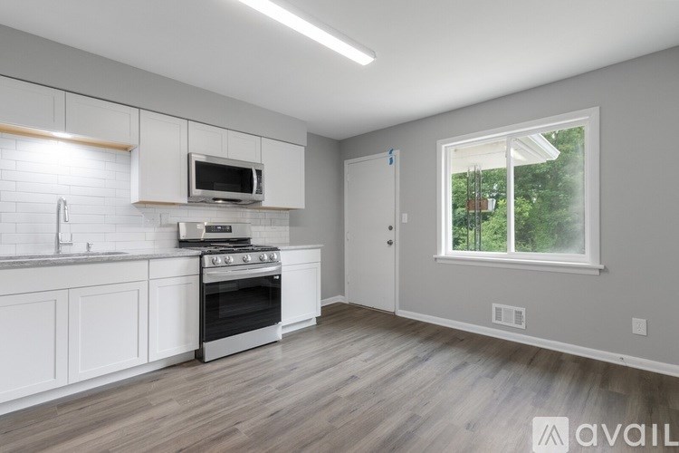 A kitchen with white cabinets and a window.