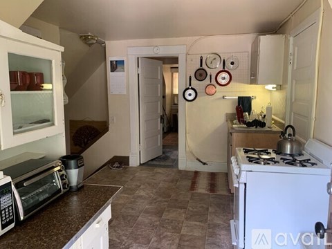 A kitchen with a white stove and a microwave on the counter.
