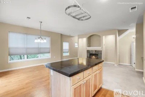 A spacious kitchen with wooden cabinets and a black countertop.