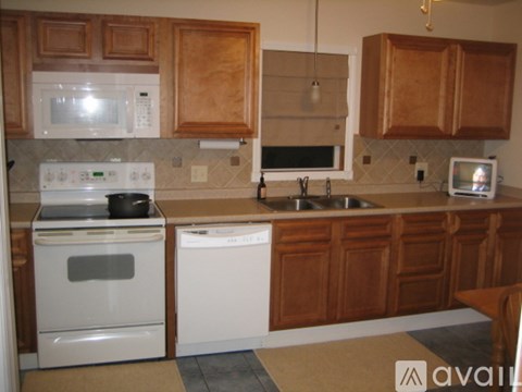 A kitchen with wooden cabinets and white appliances.