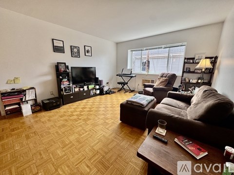 A living room with a brown couch, a wooden coffee table, and a television on a stand.