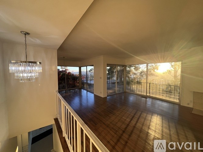 A living room with a balcony and a chandelier.