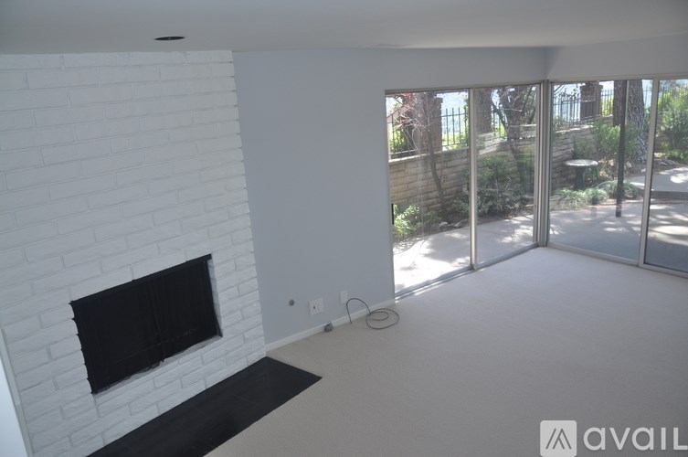 A white room with a fireplace and a large window.