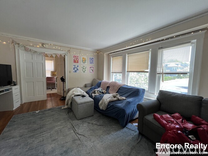 A living room with a grey couch and a blue blanket on it.