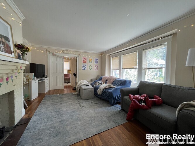 A living room with a grey couch and a fireplace.