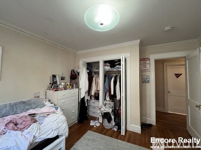 A bedroom with a bed, dresser, and closet.