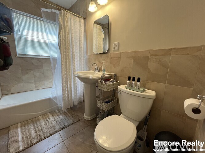 A bathroom with a toilet, sink, and shower.
