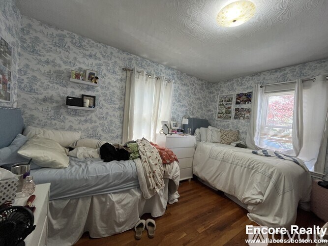 A bedroom with two beds and a window.