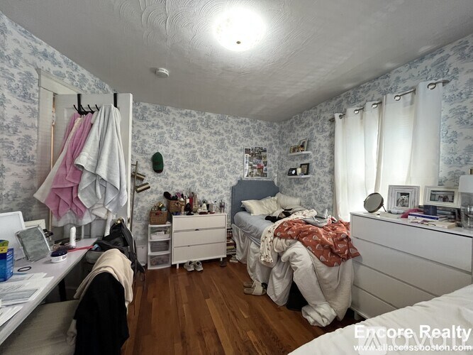A bedroom with a bed, dresser, and mirror.