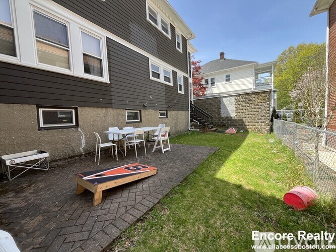 A patio with a table and chairs is surrounded by a brick wall.