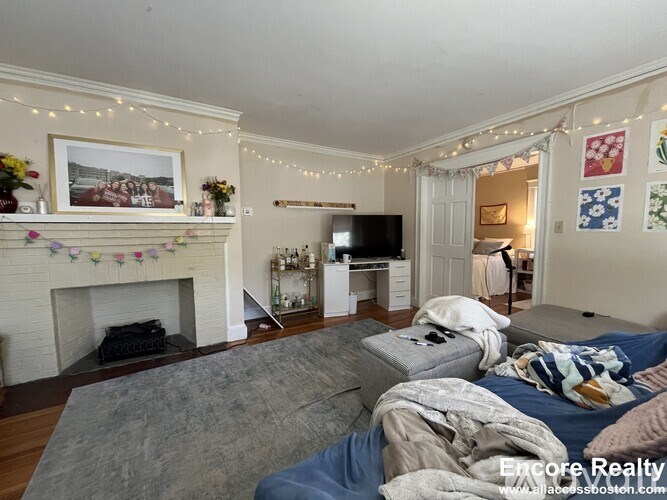 A living room with a fireplace and a grey sofa.