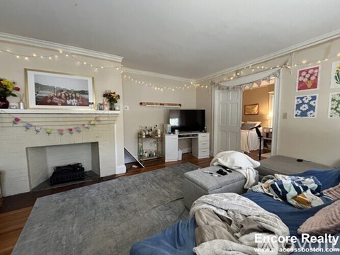 A living room with a fireplace and a grey sofa.
