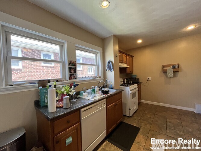A kitchen with a stove top oven and a washing machine.