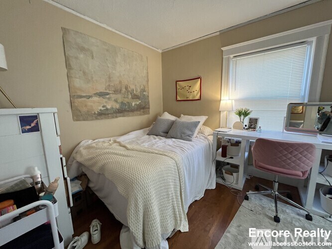 A bedroom with a bed, desk, and chair.