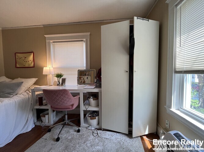 A bedroom with a bed, desk, and chair.