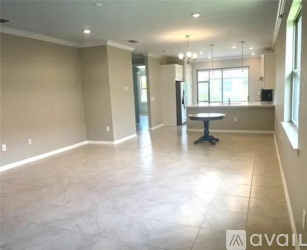 A spacious room with a table and chairs in the center.