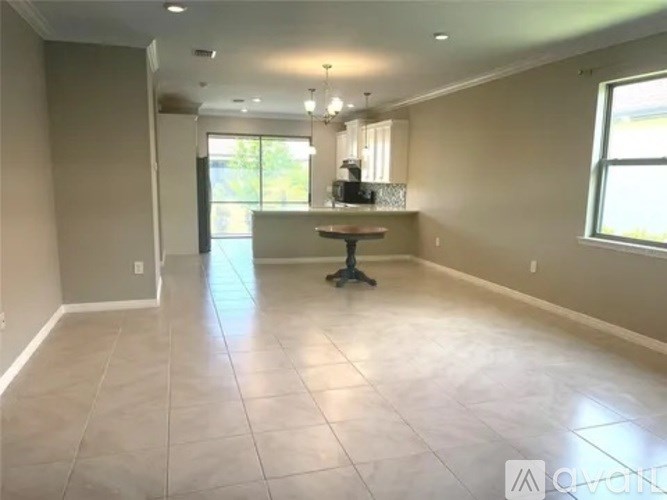 A spacious room with a table and chairs in the center.