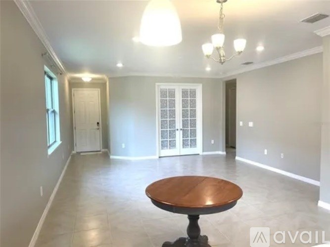 A spacious room with a wooden table in the center.