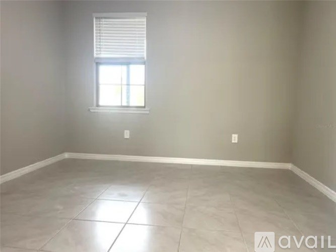 A room with a window and tiled floor.