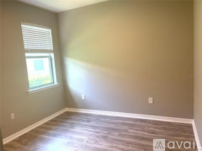 A room with a window and wooden flooring.