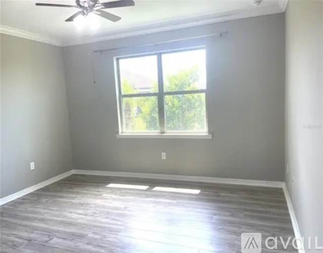 A room with a ceiling fan and a window.