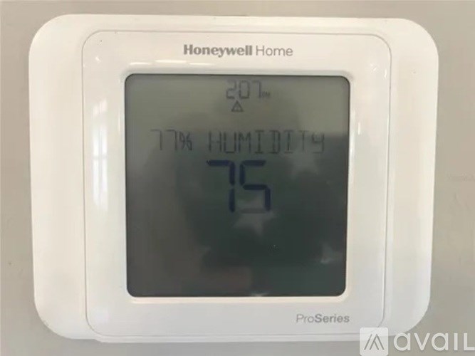 A Honeywell Home ProSeries thermostat shows the temperature is 75 degrees and the humidity is 77 percent.