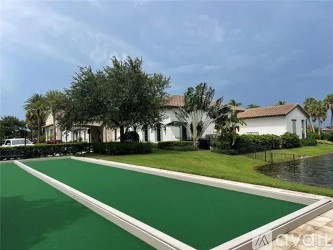 A house with a green lawn and a pool in front.
