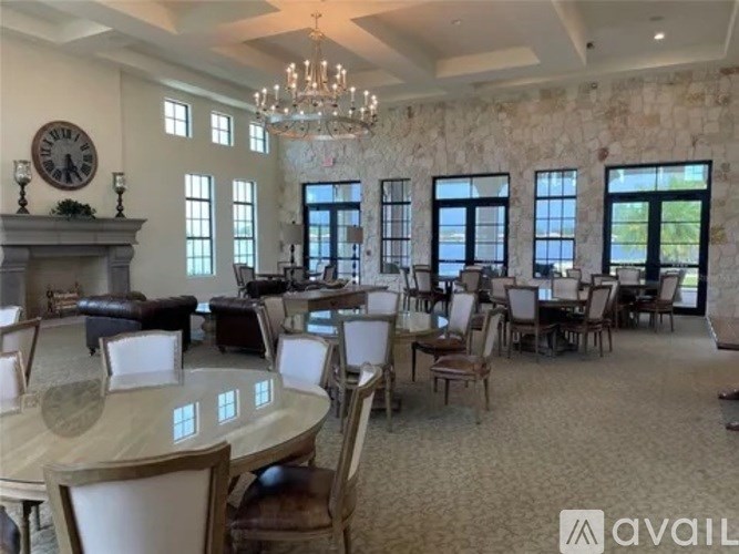 A large, well-lit dining room with a stone wall and a chandelier.