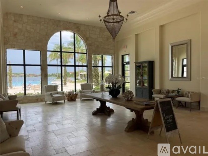 A large, well-lit room with a view of the ocean through large windows.