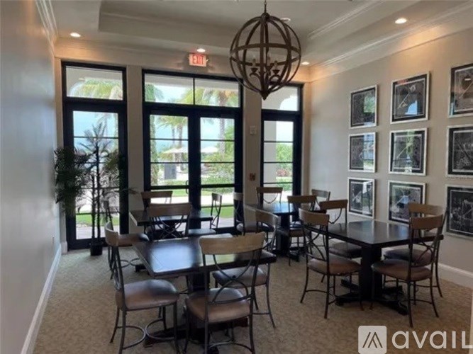 A dining room with a table set for six and a view of the backyard through the windows.