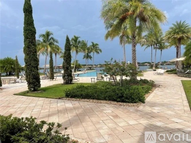 A patio area with a pool surrounded by palm trees.