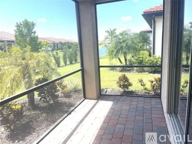 A balcony with a view of a garden and houses.