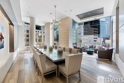 A modern dining room with a glass table and chairs.