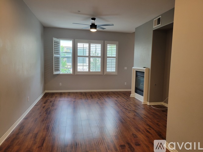 A room with wooden floors and a ceiling fan.