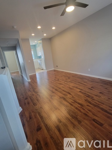 A room with wooden flooring and a ceiling fan.
