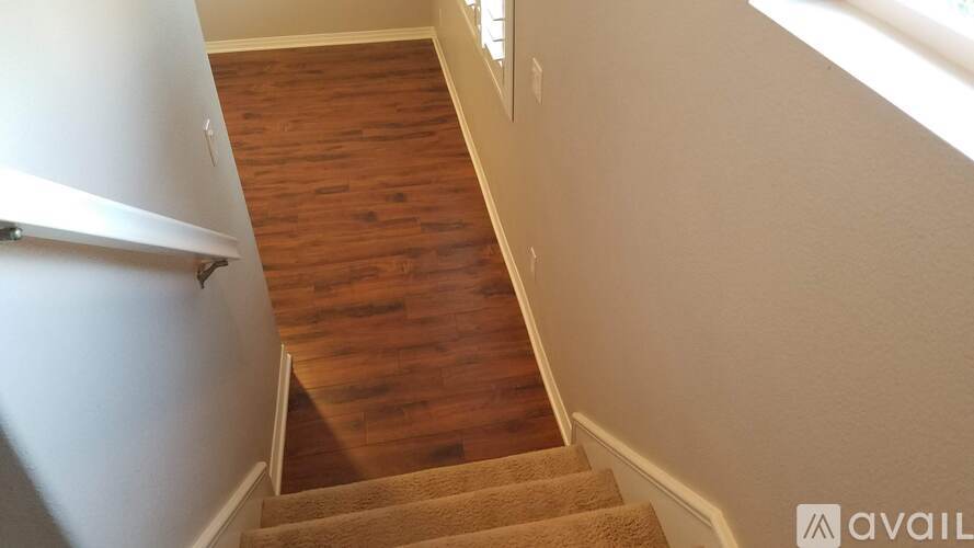 A wooden staircase with a white wall on the side.