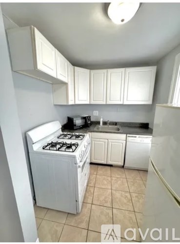 A kitchen with white cabinets and a white stove.