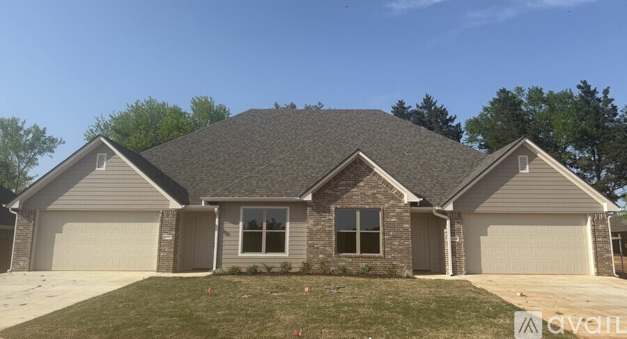 A house with a grey roof and two garages.