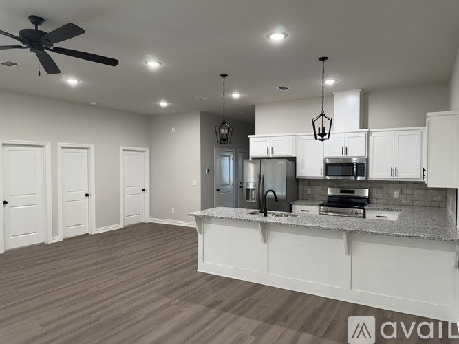A spacious kitchen with white cabinets and a central island.