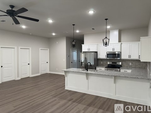 A spacious kitchen with white cabinets and a central island.