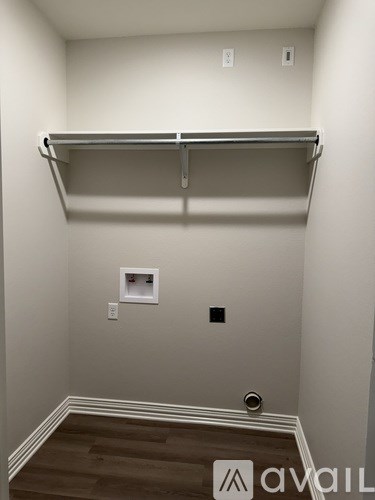 A wall-mounted shelf in a room with a wooden floor.